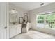 Charming bathroom featuring double sinks, vanity space, and a window offering serene outdoor views and ample natural light at 601 Carver Pond Ln, Waxhaw, NC 28173