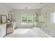 Bright bathroom featuring a soaking tub, glass shower, and a large window offering natural light and serene views at 601 Carver Pond Ln, Waxhaw, NC 28173