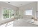 Elegant bathroom with a soaking tub, glass-enclosed shower, and multiple windows for natural light and backyard views at 601 Carver Pond Ln, Waxhaw, NC 28173