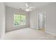 Bright bedroom with neutral carpet, ceiling fan, and a window that offers natural light and peaceful outdoor views at 601 Carver Pond Ln, Waxhaw, NC 28173