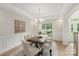 Elegant dining room featuring detailed trim work, natural light, and a modern chandelier above a dining table at 601 Carver Pond Ln, Waxhaw, NC 28173