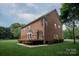 Expansive backyard of a brick home featuring a deck, lawn, and verdant landscaping at 601 Carver Pond Ln, Waxhaw, NC 28173