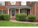 Elegant brick home entrance with white columns and detailed front door with manicured shrubbery at 601 Carver Pond Ln, Waxhaw, NC 28173