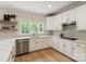 Well-lit kitchen featuring white cabinets, countertops, a sink, and stainless steel appliances at 601 Carver Pond Ln, Waxhaw, NC 28173