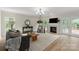 Cozy living room with hardwood floors, fireplace, and natural light from large windows at 601 Carver Pond Ln, Waxhaw, NC 28173