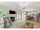 Open-concept living room with fireplace, hardwood floors, and seamless flow to dining and kitchen at 601 Carver Pond Ln, Waxhaw, NC 28173