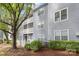 Apartment complex with gray siding, white trim, balconies, and a mature tree in the yard at 6011 Treetop Ct, Charlotte, NC 28212
