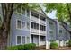 This building has two stories, white railings, green plants and a blue door at 6011 Treetop Ct, Charlotte, NC 28212