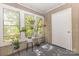 Sunroom featuring many windows with wooden paneling and a collection of potted plants at 6011 Treetop Ct, Charlotte, NC 28212