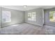 Bright bedroom with neutral carpeting and large windows offering natural light and neighborhood views at 6027 Veld Ct # 82, Charlotte, NC 28215
