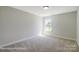 Bright bedroom with plush carpeting, light gray walls, and a window for natural light at 6027 Veld Ct # 82, Charlotte, NC 28215