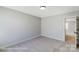 Neutral bedroom with plush carpeting, light gray walls, and a glimpse into the hallway at 6027 Veld Ct # 82, Charlotte, NC 28215