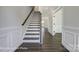 Welcoming foyer with hardwood floors, a staircase with dark handrail, and decorative trim at 6027 Veld Ct # 82, Charlotte, NC 28215