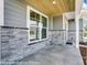 Inviting front porch with stone accents, siding and wood ceiling at 6027 Veld Ct # 82, Charlotte, NC 28215