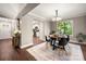 Inviting dining area featuring hardwood floors, neutral paint, a modern chandelier, and large window overlooking the backyard at 7 Turtle Ln, Clover, SC 29710