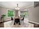 Dining area with hardwood floors, neutral paint, a modern chandelier, and a large window showcasing the private backyard at 7 Turtle Ln, Clover, SC 29710