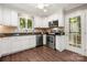 Well-lit kitchen with white cabinets, granite countertops, and stainless steel appliances at 7 Turtle Ln, Clover, SC 29710