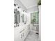 Modern bathroom featuring double vanity with black hardware, marble floors, and a glass block window at 7328 S Providence Rd, Waxhaw, NC 28173