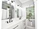 Modern bathroom featuring double vanity with black hardware, marble floors, and a glass block window at 7328 S Providence Rd, Waxhaw, NC 28173