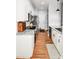 Galley kitchen with white cabinets, hardwood floors, and stainless appliances at 7328 S Providence Rd, Waxhaw, NC 28173