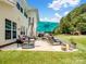 Relaxing backyard patio with comfortable seating, an umbrella, and decorative potted plants at 7627 Woodcrest Dr, Stanley, NC 28164