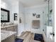 Bright bathroom featuring modern vanity with granite counters, framed mirror, and frameless glass shower at 7627 Woodcrest Dr, Stanley, NC 28164