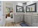 Bathroom with double vanity, granite counters, framed mirrors, and a view into the serene bedroom at 7627 Woodcrest Dr, Stanley, NC 28164