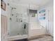 This bright bathroom features a glass-enclosed shower and a soaking tub for relaxation and comfort at 7627 Woodcrest Dr, Stanley, NC 28164