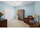 Bedroom featuring blue walls, a cozy chair, and a bookshelf for a serene and comfortable retreat at 7627 Woodcrest Dr, Stanley, NC 28164