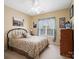 Cozy bedroom with neutral walls, ceiling fan, and window adorned with curtains at 7627 Woodcrest Dr, Stanley, NC 28164