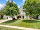 Charming two-story home with a well-manicured lawn, mature trees, and a welcoming front porch at 7627 Woodcrest Dr, Stanley, NC 28164
