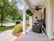 Cozy front porch featuring comfortable seating, neutral accents, and a ceiling fan for relaxed outdoor living at 7627 Woodcrest Dr, Stanley, NC 28164