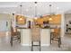 Bright kitchen features wooden cabinetry, a modern island with barstool seating, and stainless steel appliances at 7627 Woodcrest Dr, Stanley, NC 28164