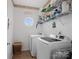 Bright laundry room features modern appliances, shelving, and a charming round window at 7627 Woodcrest Dr, Stanley, NC 28164