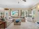 Spacious living room featuring neutral walls, large windows, and a view into the bright dining area at 7627 Woodcrest Dr, Stanley, NC 28164