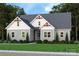Charming one-story home with light-green siding, gray roof, manicured lawn, and complemented by mature trees at 1061 The Glen St, Statesville, NC 28677