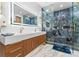 Stylish bathroom boasts a double vanity, illuminated mirror, and luxurious glass shower with elegant tiling and golden accents at 120 Lakeshore Dr, Mooresville, NC 28117