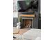 Living room featuring a modern fireplace with a wooden mantel, dark accent wall, and built-in cabinets at 120 Lakeshore Dr, Mooresville, NC 28117