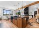 View of a spacious kitchen with an island, wood cabinets, and modern lighting, connecting to the living room at 120 Lakeshore Dr, Mooresville, NC 28117