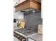 A gourmet kitchen features a stainless steel stove and hood with custom cabinets and dark backsplash at 120 Lakeshore Dr, Mooresville, NC 28117