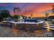 Outdoor pool featuring a stone waterfall, an adjacent fire pit, and a picturesque sunset backdrop at 120 Lakeshore Dr, Mooresville, NC 28117