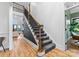 Interior staircase with wrought iron railings, elegant carpet, and warm wood flooring, leading to a light-filled space at 120 Lakeshore Dr, Mooresville, NC 28117