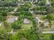 Aerial view of a neighborhood showcasing a home with a circular driveway surrounded by lush greenery and trees at 124 Courtney Ln, Matthews, NC 28105
