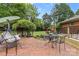 Relaxing backyard with brick patio, lush greenery, and comfortable porch swing seating area at 124 Courtney Ln, Matthews, NC 28105