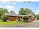 Backyard featuring a brick home exterior, wooden deck, and landscaping, complemented by a gravel area at 124 Courtney Ln, Matthews, NC 28105
