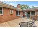 Backyard featuring a brick house and a wooden deck with outdoor furniture, and a well-maintained lawn at 124 Courtney Ln, Matthews, NC 28105