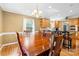 Dining area showcasing a large table and chairs, wooden floors, stylish lighting, with kitchen access at 124 Courtney Ln, Matthews, NC 28105