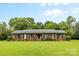 Charming single story brick home with a well-maintained lawn, mature trees and green shutters at 124 Courtney Ln, Matthews, NC 28105