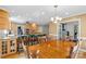 An open concept kitchen and dining area featuring wood cabinets, hardwood floors, and modern lighting at 124 Courtney Ln, Matthews, NC 28105