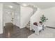 Bright entryway with wood floors, coat closet, and staircase leading to the second floor and accent chairs at 129 Canada Dr # 85, Statesville, NC 28166